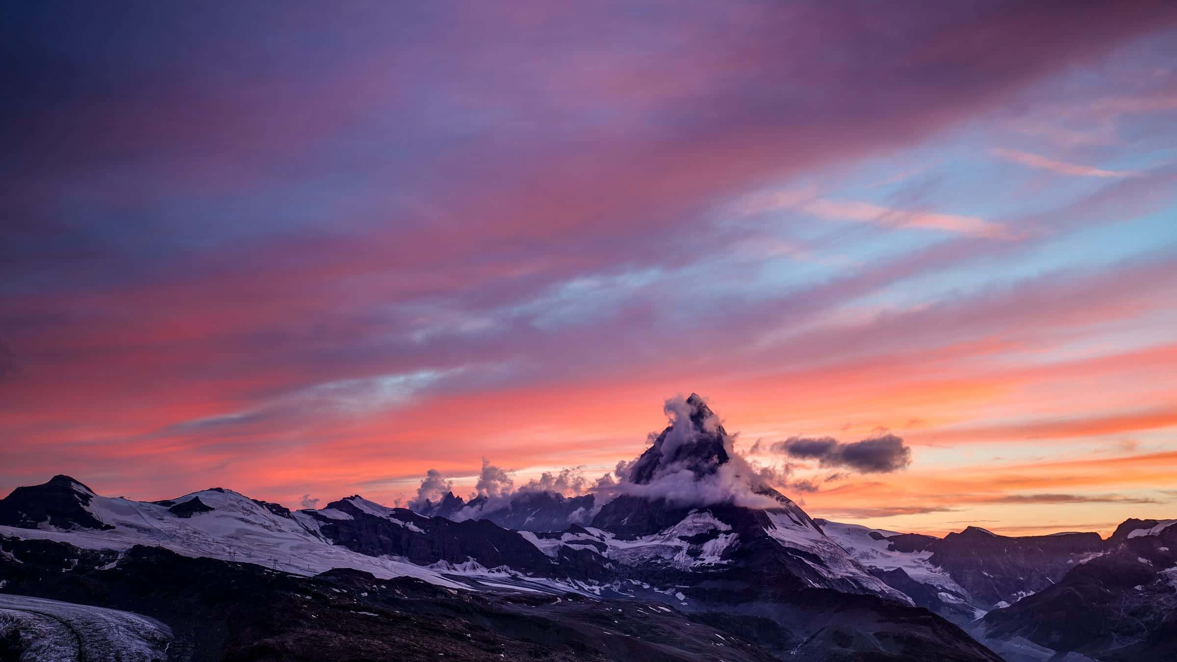 The snow-covered Matterhorn under a streaked pink and violet sky