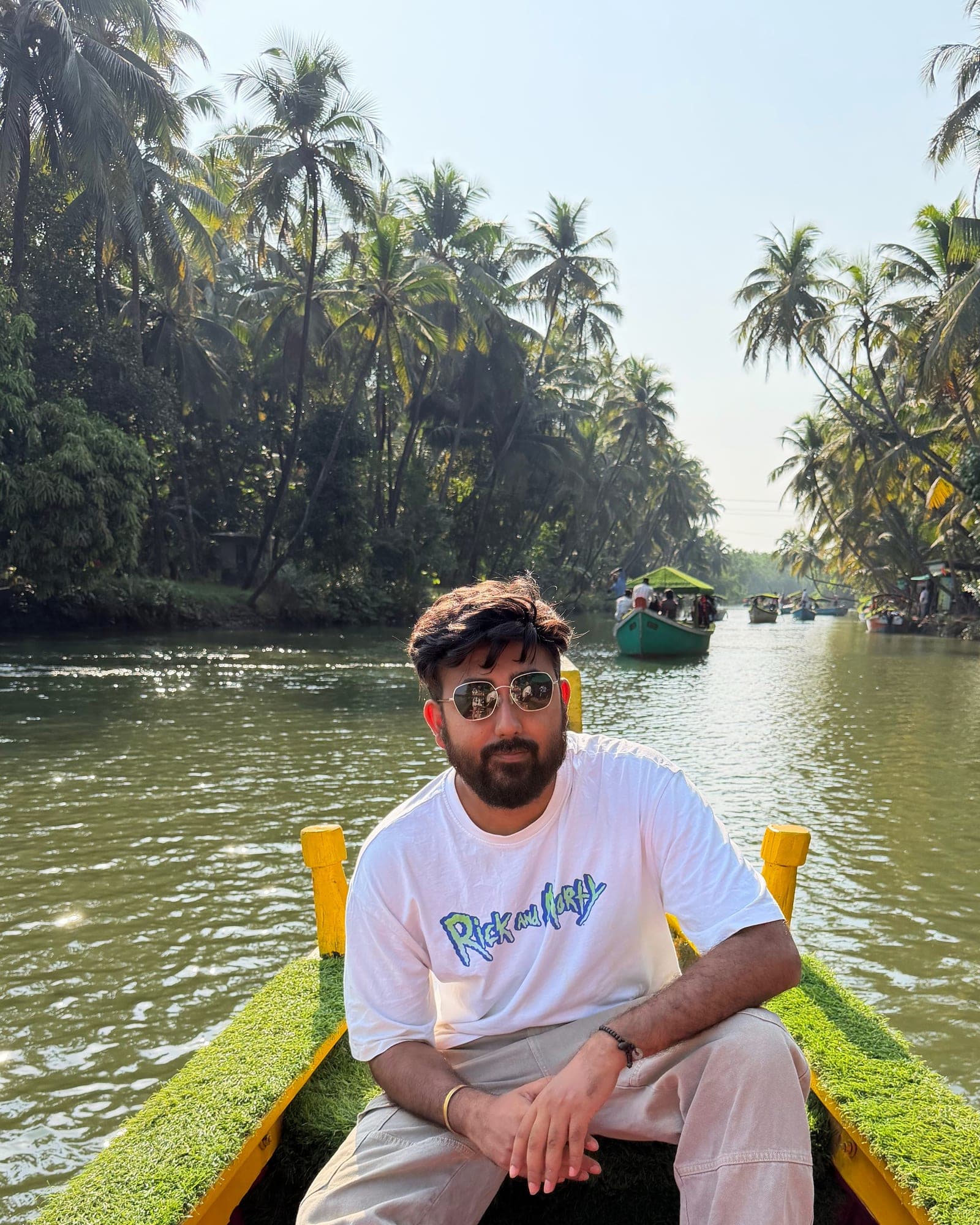 Anurag Gautam seated in a boat on a palm-lined river