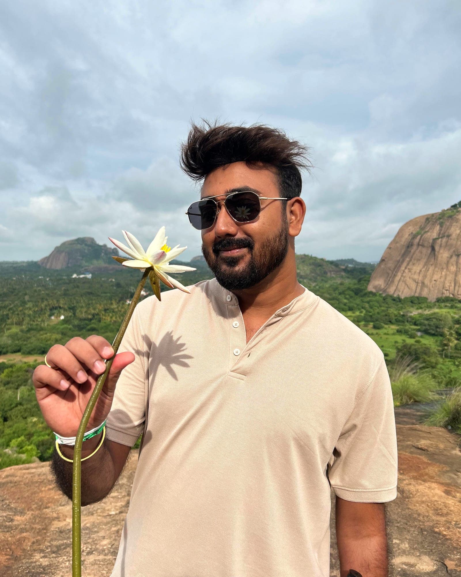 Anurag Gautam on a granite hilltop above a green valley