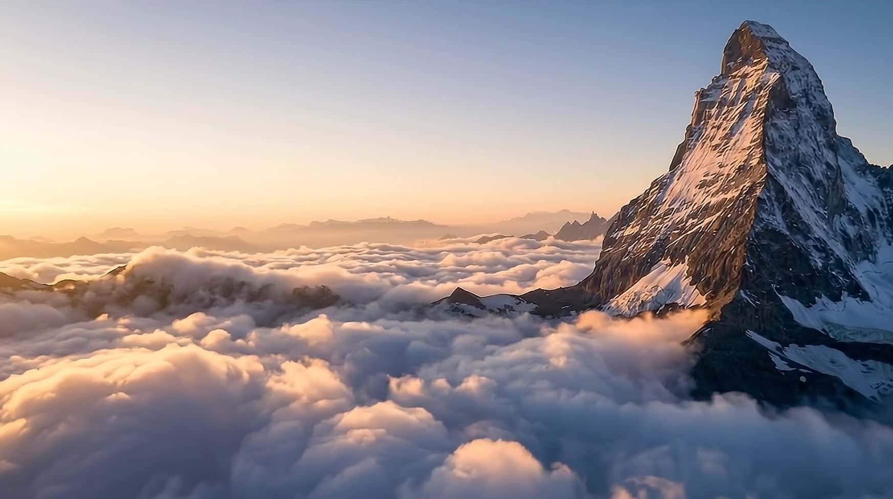Low over a golden, back-lit sea of cloud at sunrise, the Matterhorn glowing on the right